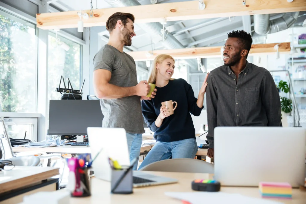 twee mannen en vrouw in het midden op office die hun dag bespreken.